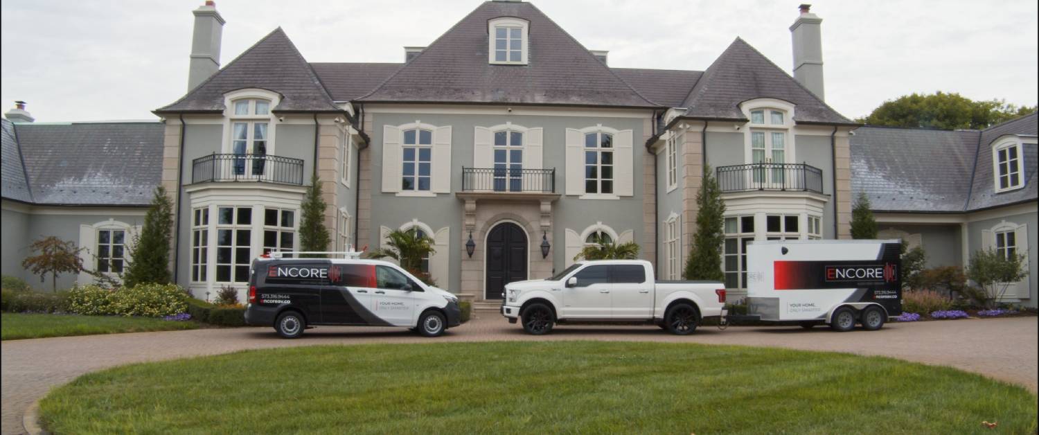 Encore Trucks in front of a big house